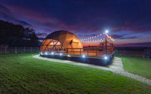 ein großes Kuppelgebäude auf einem Feld in der Nacht in der Unterkunft The Dome Breaza (BV) in Breaza