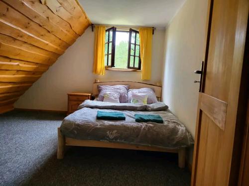um quarto com uma cama e uma janela com cortinas amarelas em Kaszubska Zagroda em Lipuska Huta