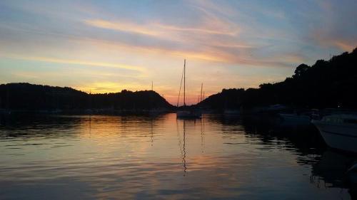 un coucher de soleil sur une étendue d'eau avec des bateaux dans l'établissement Dimitri's Seaview Studio - Lakka Paxos, à Lakka