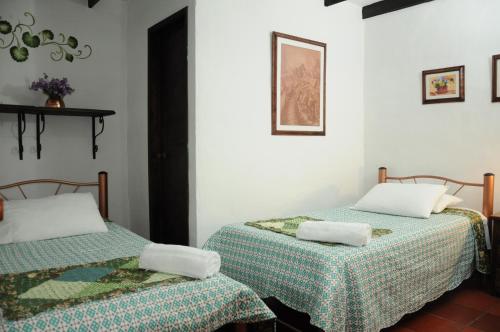 two beds sitting next to each other in a room at Hospedaje La Casona in Tabio
