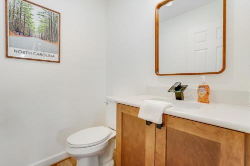 ein Badezimmer mit einer weißen Toilette und einem Spiegel in der Unterkunft Brookshire Townhome in Boone