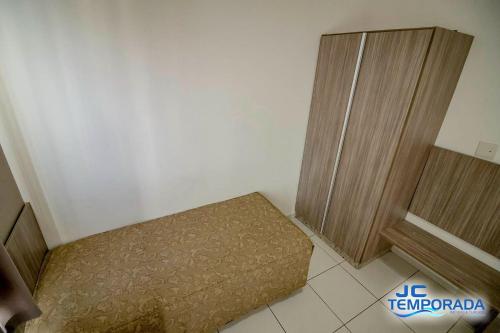 a small room with a bed and wooden doors at Riviera Park in Caldas Novas