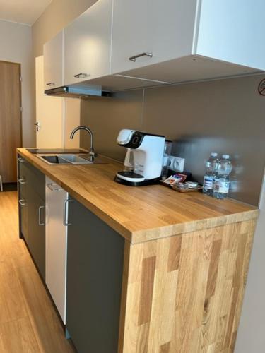 a kitchen with a wooden counter top with a sink and aounter at Apartament Bastion Wałowa Gdańsk in Gdańsk