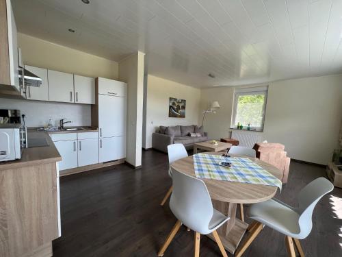 a kitchen and a dining room with a table and chairs at Landferien Eifel in Pittenbach