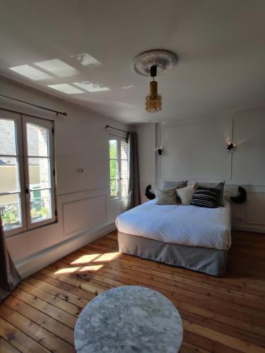 a bedroom with a bed and a table at MAISON SEIZE in Préaux