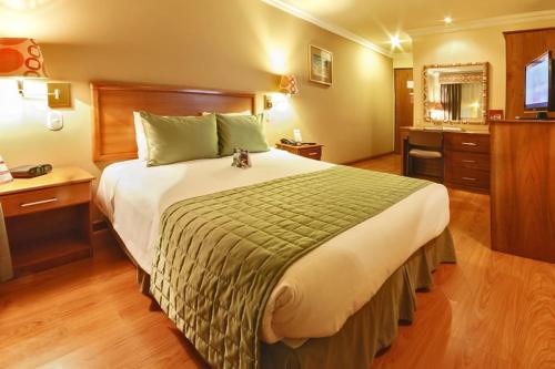 a bedroom with a large bed in a hotel room at Hotel El Conquistador in Cuenca