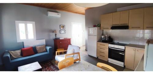 a kitchen with a blue couch and a kitchen with a stove at Artemis House in Krokeaí