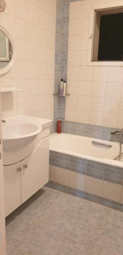 a white bathroom with a sink and a tub and a sink at SUPER APART A CITE EL KHADHRA in Tunis