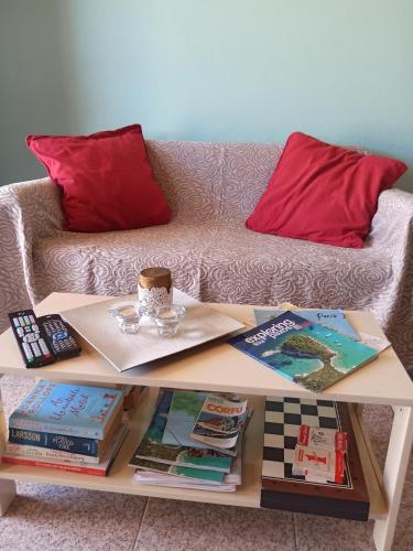a coffee table with books on it with a couch at Dimitri's Seaview Studio - Lakka Paxos in Lákka