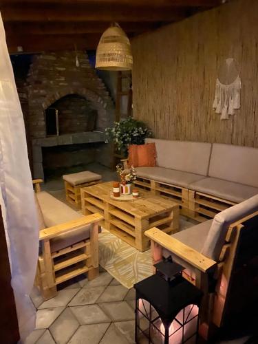 a living room with a couch and tables and a fireplace at Apartmani Lazarevic Jagodina in Jagodina
