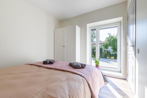 ein Schlafzimmer mit großem Bett und Fenster in der Unterkunft Apartamentai su terasa in Palanga