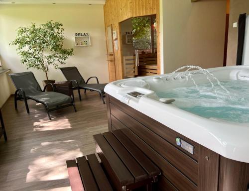 a bathroom with a tub with chairs and a table at Landferien Eifel in Pittenbach