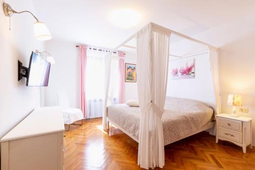a bedroom with a canopy bed and a wooden floor at Casa Lilly in Labin