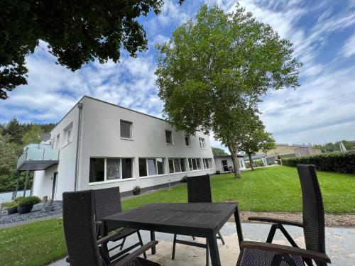 a table and chairs in front of a building at Landferien Eifel in Pittenbach