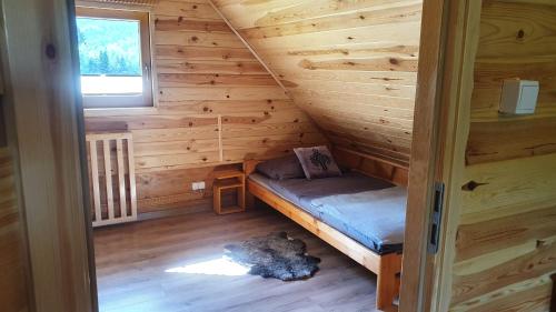 a small room with a bed in a log cabin at Jodłowa Chata in Myślenice