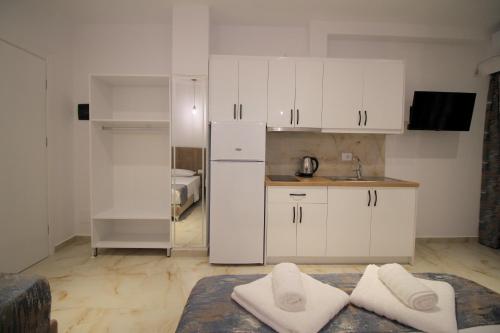 a kitchen with white cabinets and a white refrigerator at Vila Ori in Ksamil