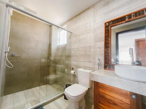 a bathroom with a shower and a toilet and a sink at Loft Grécia In in Arraial do Cabo
