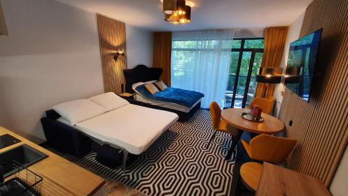 un piccolo soggiorno con letto e tavolo di Gold Horizon Apartament Solny Resort a Kołobrzeg