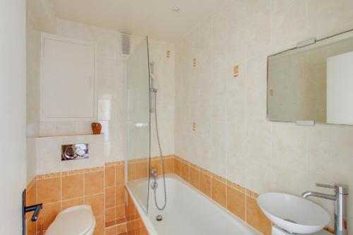 une salle de bain avec une baignoire, un lavabo et une douche dans l'établissement Elegant appartement près de la Tour Eiffel by Weekome, à Paris