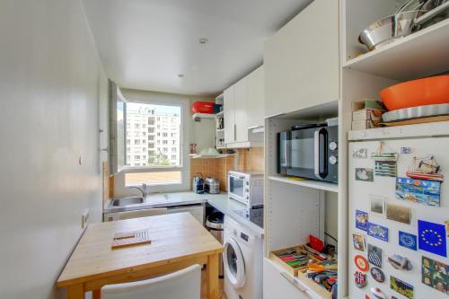 une petite cuisine avec une table et un réfrigérateur dans l'établissement Elegant appartement près de la Tour Eiffel by Weekome, à Paris