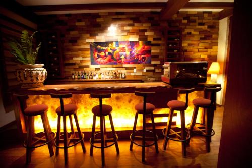 a bar with stools in front of a fireplace at Casa del Sol Machupicchu in Machu Picchu