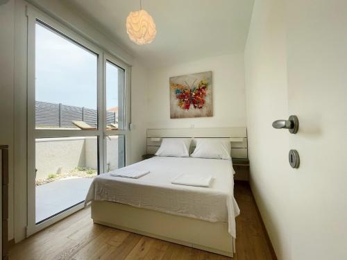 a bedroom with a bed and a large window at Cozy seaside apartment with pool & terrace in Split