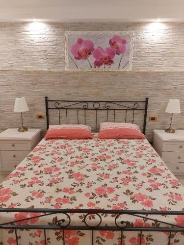 um quarto com uma cama com colcha floral em Mivigio em Bari