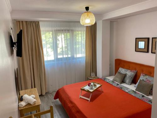 a bedroom with a red bed with a table on it at Glam Boutique in Mangalia