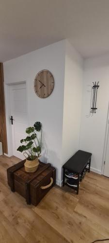 een kamer met een klok aan de muur en een tafel bij Apartament Maja in Jantar