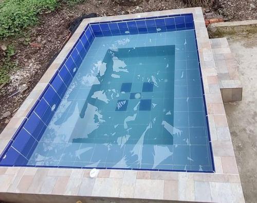 a swimming pool with blue tiles on the ground at CASALOMA in La Vega