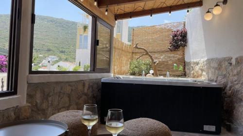 a bathroom with a tub and two glasses of wine at ViSun Apartment 3 in Vis