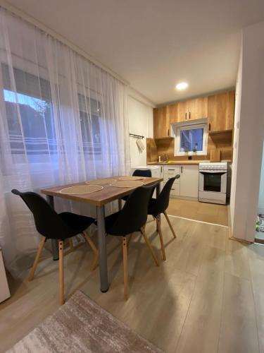a dining room table and chairs in a kitchen at Apartmani Lazarevic Jagodina in Jagodina