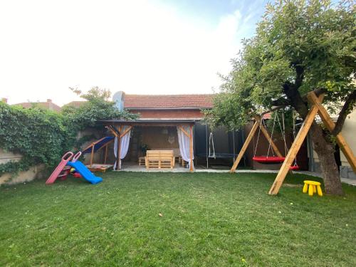 a backyard with a play area with a tree at Apartmani Lazarevic Jagodina in Jagodina