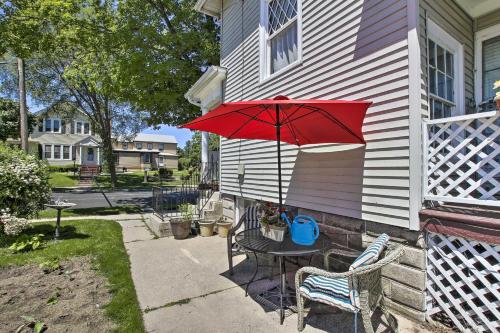 a patio with a table and a red umbrella at Eclectic Manitowoc Vacation Rental Near Marina! in Manitowoc