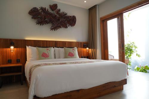 a bedroom with a large bed and a large window at Umah Anyar in Canggu