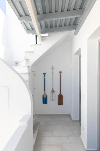 a white hallway with axes on the wall at Kamvas Deluxe Apartments in Naxos Chora