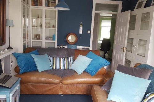 a living room with a brown couch with blue pillows at Galway City Lovely 2 Bed Apartment in Galway