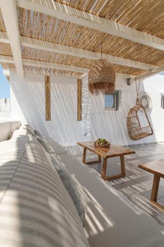 a patio with a wooden table and a bench at Kamvas Deluxe Apartments in Naxos Chora