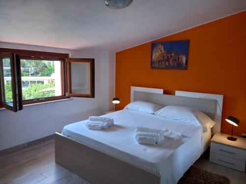 a bedroom with a large white bed with orange walls at Cialoma Full Green in Marina di Camerota