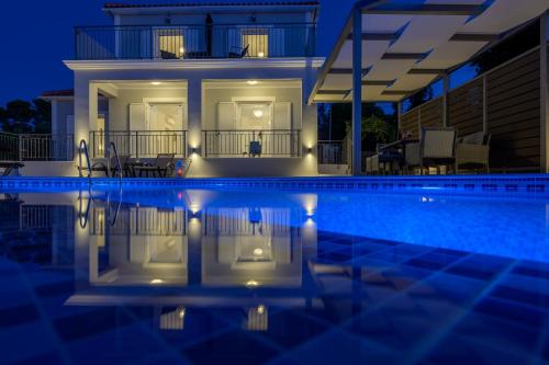a house with a swimming pool at night at VILLA EKTAMA in Fiskardho