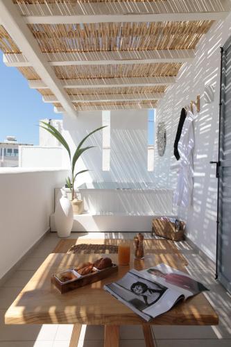 a living room with a wooden table in the middle at Kamvas Deluxe Apartments in Naxos Chora