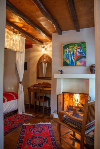 a living room with a fireplace and a dining table at Archontiko Stamou in Zagora