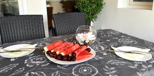 a table with a plate of fruit and a glass of wine at Ric Apartment Budva in Budva