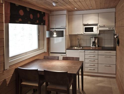 a kitchen with a table and chairs and a microwave at Keurusharju Apartments in Keuruu