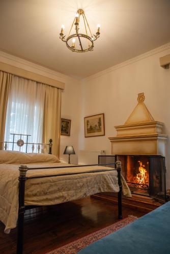 a bedroom with a bed and a fireplace at Archontiko Stamou in Zagora