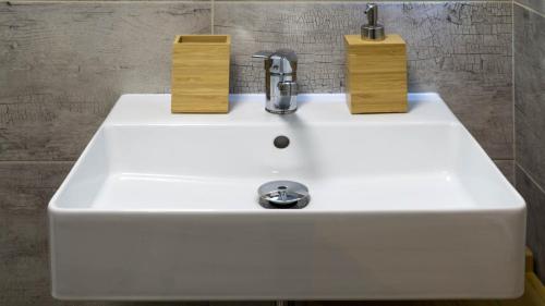 a white sink with two wooden blocks on it at Flying Bed Apartment close to Prague Castle and Airport in Prague