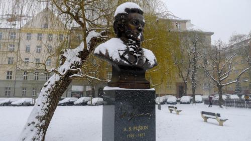 a statue in the snow next to a tree at Flying Bed Apartment close to Prague Castle and Airport in Prague