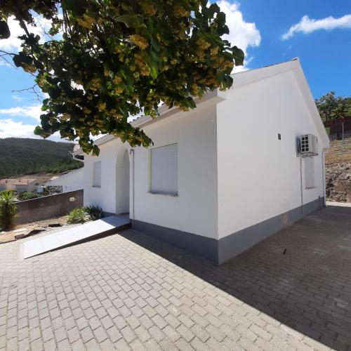 a white house with a brick driveway at Casa Rural "Casa da Professora" - Meãs, Pampilhosa da Serra in Pampilhosa da Serra