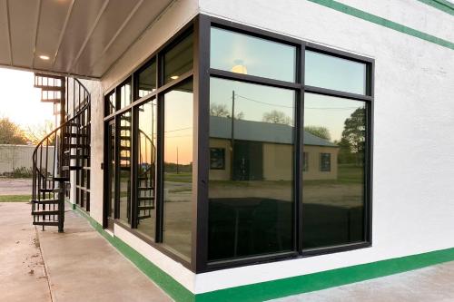 a building with large glass windows and a staircase at Unique Texas Home in Converted Gas Station! in Schulenburg