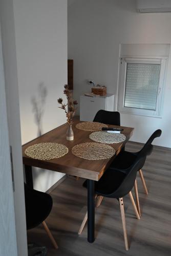 a wooden table with two black chairs and a dining room at Apartmani Lazarevic Jagodina in Jagodina